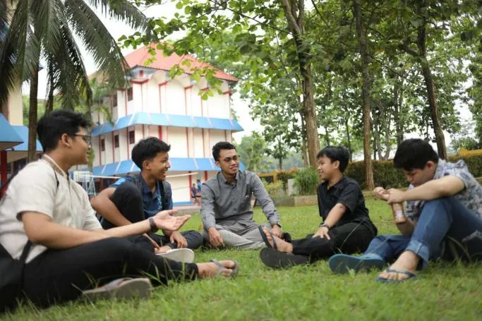 Siswa berdiskusi bersama pembina di halaman asrama
