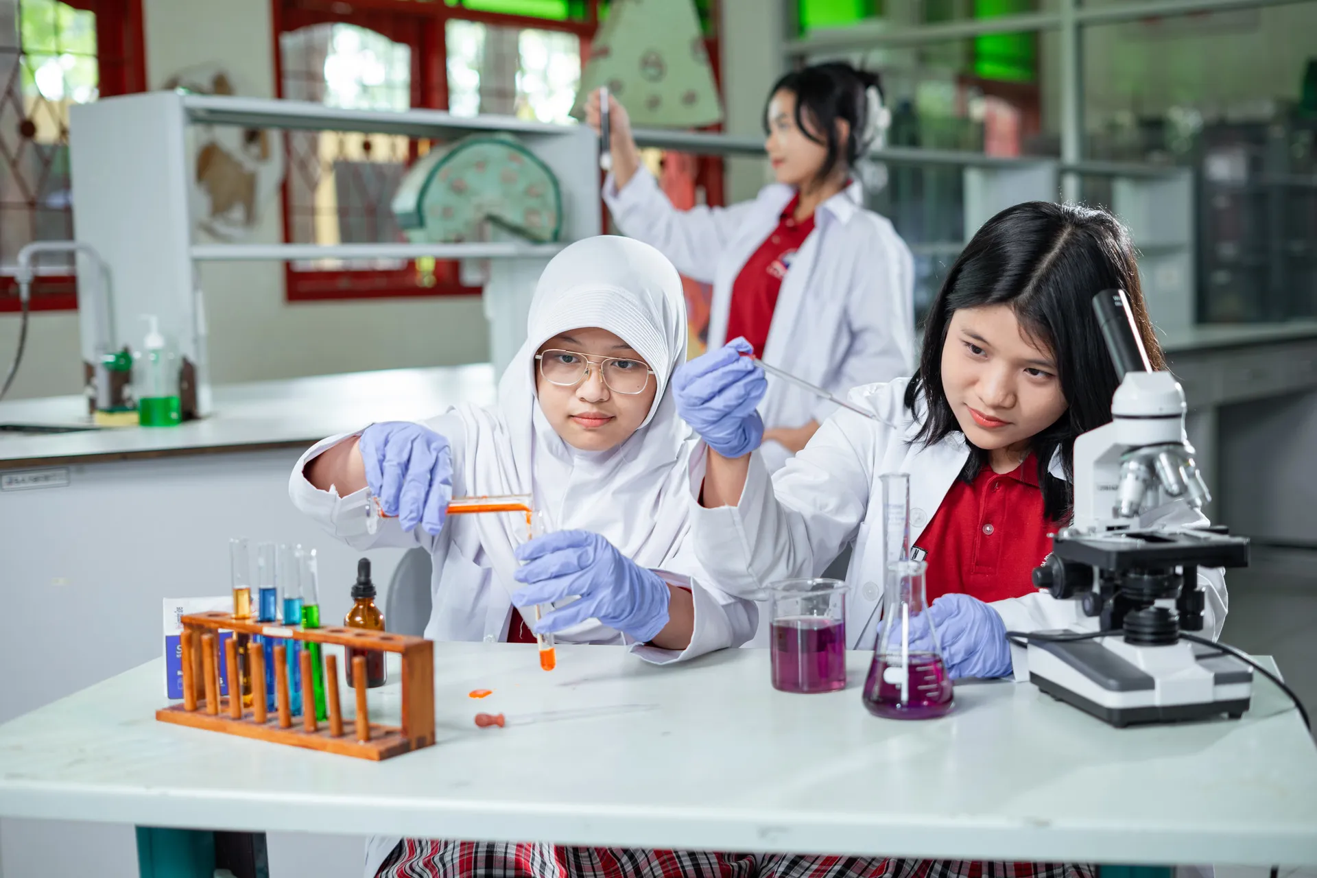 Dua siswi bereksperimen di laboratorium